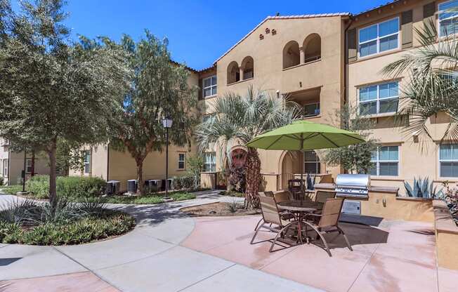 a patio with chairs and an umbrella in front of a building