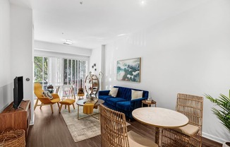 A living room with a blue couch and wooden furniture.