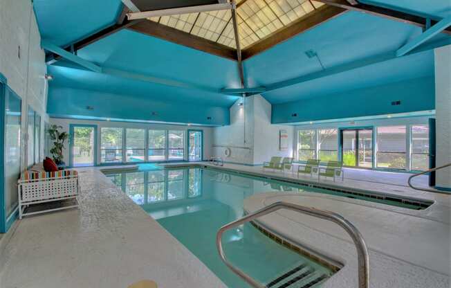 a large indoor swimming pool with a large windowed ceiling