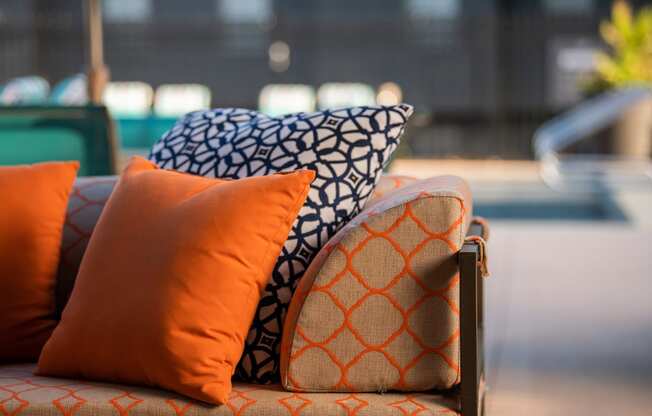 a couch with orange and blue pillows