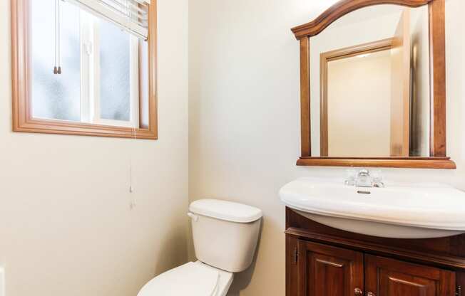 a bathroom with a toilet sink and mirror