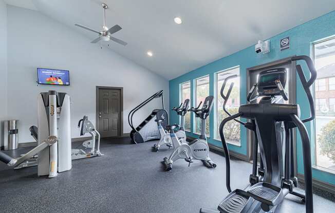A gym with a variety of equipment including treadmills, stationary bikes, and weight machines.