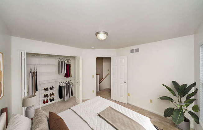 A bedroom with a bed, and a closet with organizers at Lynbrook Apartment Homes and Townhomes, Elkhorn