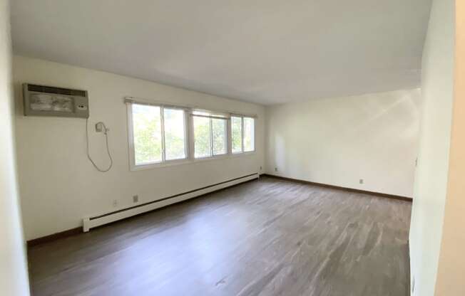 an empty room with white walls and a large window