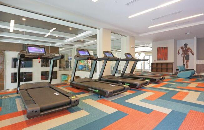 a gym with treadmills on the floor