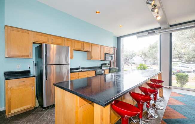 a kitchen with an island and red bar stools