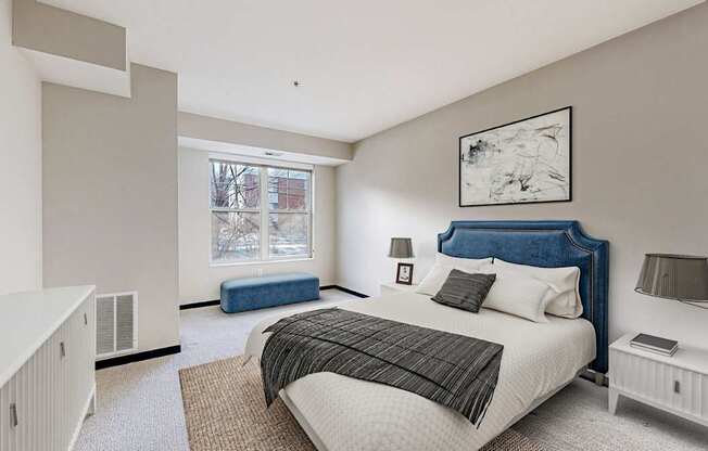 A bedroom with a large bed and a window seat.