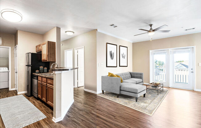 a living room with a couch and a coffee table next to a kitchen with a stove and