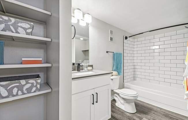 a white bathroom with a white toilet and a tub and a sink