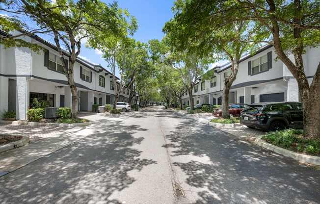 a tree lined street with houses on either side of it