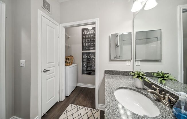 A bathroom with a white sink and a mirror.