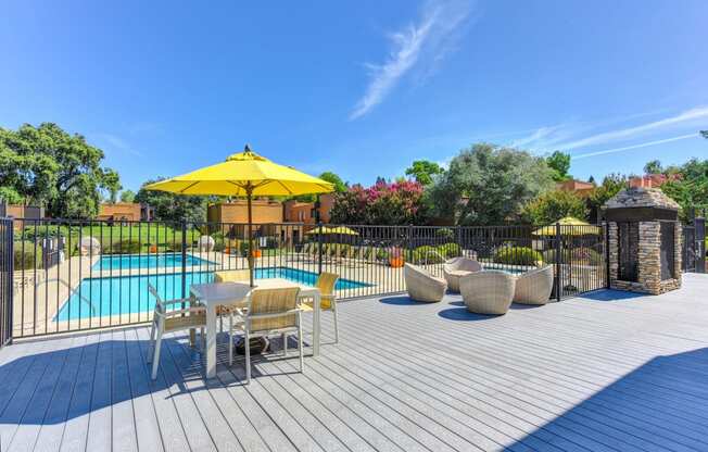 Pool Lounge  Area  with Yellow Umbrellas, Grills, Wicker Chairs, Gates with View of Pool