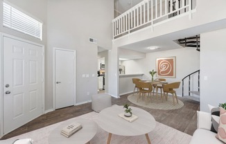 a living room with a dining room and a staircase