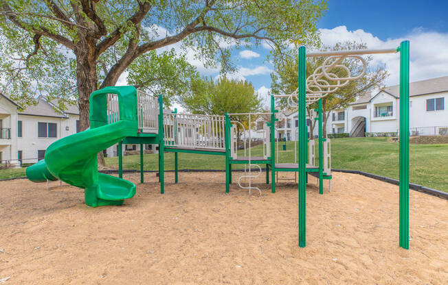 a playground with a slide and swings in a park