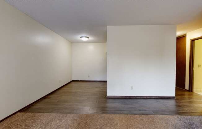 a bedroom with white walls and a dark wood floor