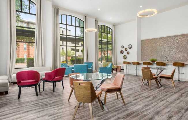 A room with a long table and chairs in front of a window.