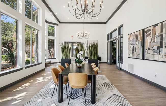 A dining room with a table set for six with chairs around it.