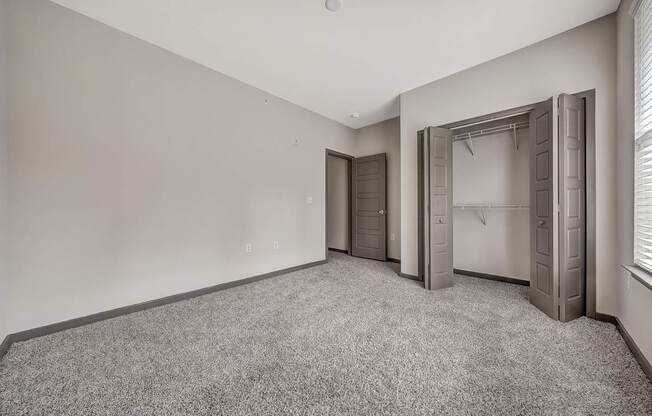 an empty room with a closet and a window