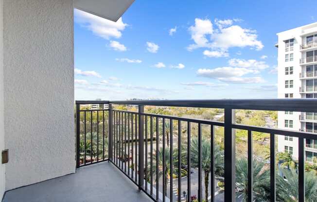 the view from the balcony of a condo with a blue sky and palm trees at One Plantation in FL 33324