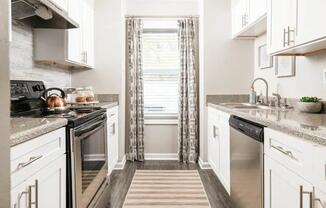 a kitchen with stainless steel appliances and white cabinets at The Sapphire, Decatur, Georgia