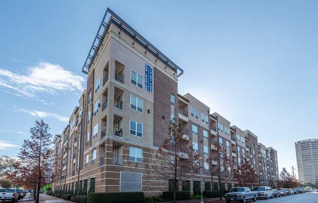 an apartment building on a street with cars parked in front of it