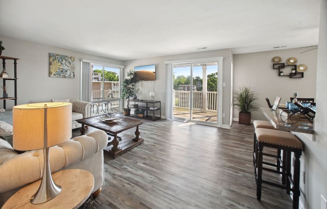 a living room with hardwood floors and a sliding glass door that leads to a balcony