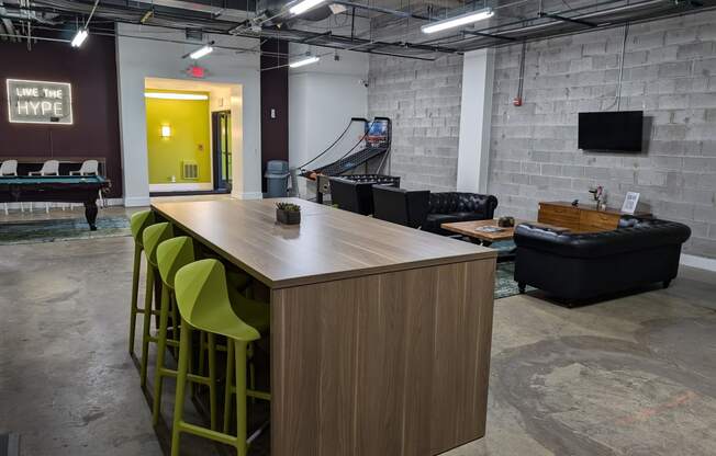 a communal table and seating area in a room with a pool table