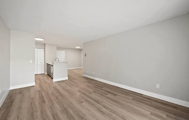 A room with wooden flooring and white walls.