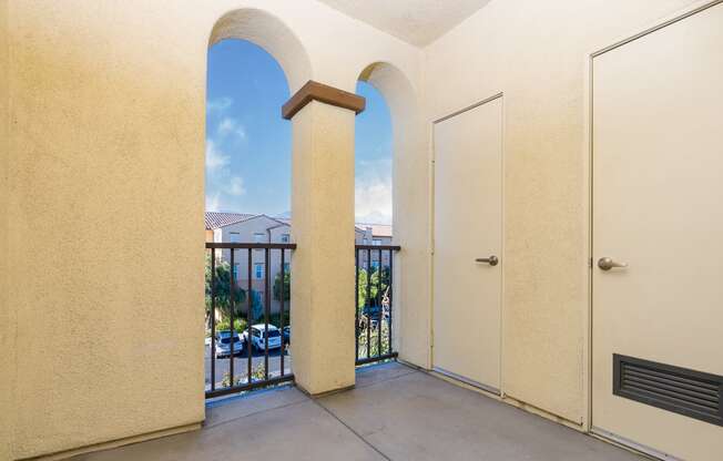 a balcony with two doors and a view of a parking lot