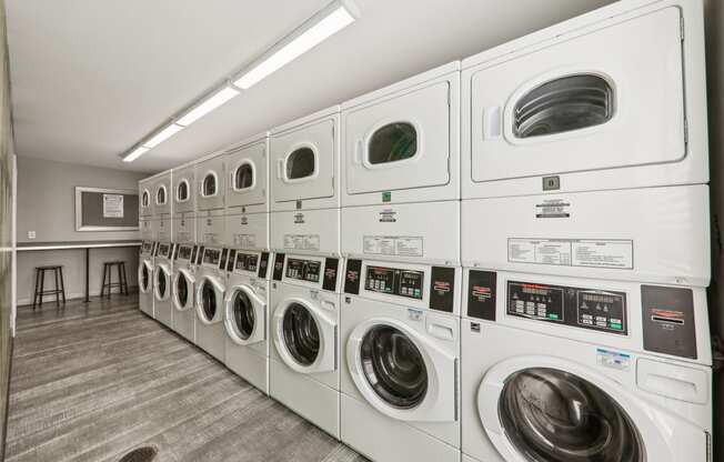 a row of washers and dryers in a laundry room