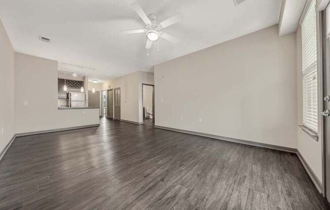 the living room and kitchen of a new home with white walls and wood floors