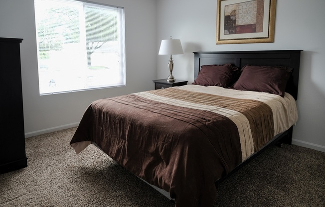 Premium unit master bedroom, mature trees outside window, natural lighting, in Regency apartments Bettendorf, Iowa