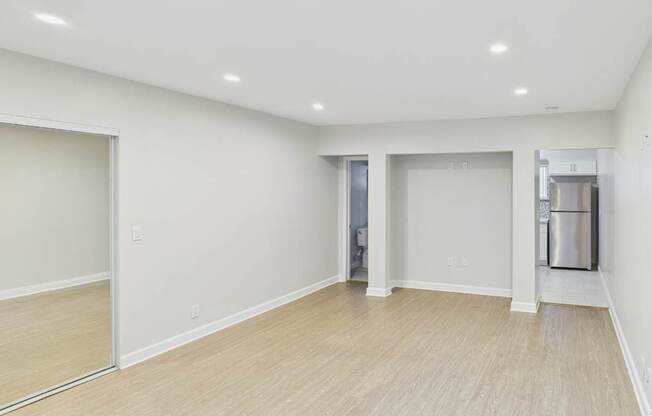 A spacious room with a door and a trash can.