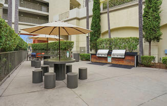 A patio with a table, chairs, and umbrella.