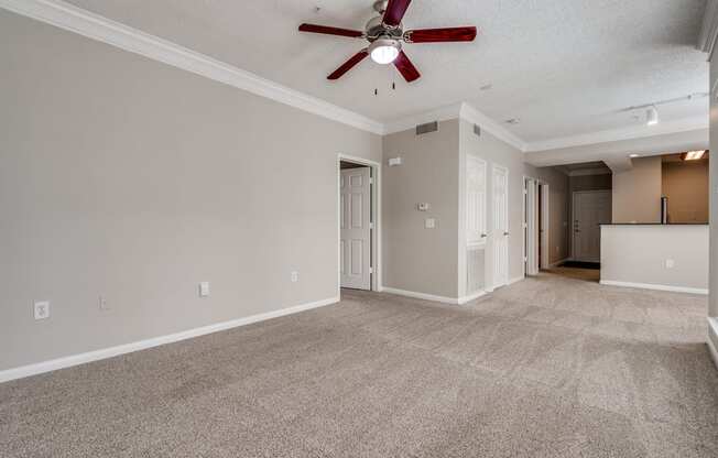 an empty living room with a ceiling fan