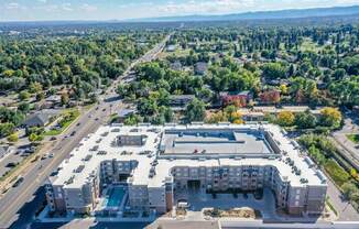 an aerial view of a large parking lot with trees in the background