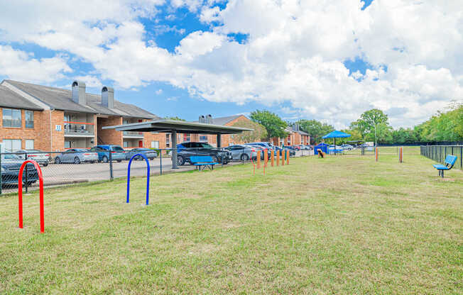 A playground with a blue umbrella and a red pole.