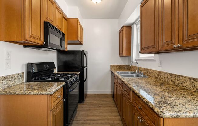 a kitchen with wooden cabinets and granite countertops