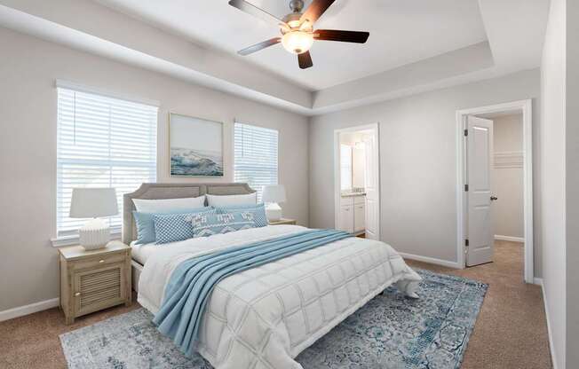 A bedroom with a bed, a ceiling fan, and a rug.