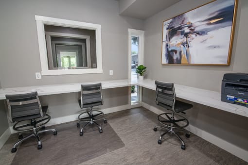 Resident business center with two chairs and a desk and a window