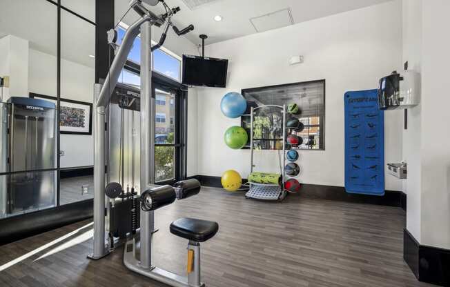 Fitness room with weights and cardio equipment - The Acadia at Cornerstar Apartments