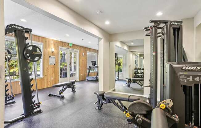 A gym with a variety of equipment including a squat rack, bench, and weights.