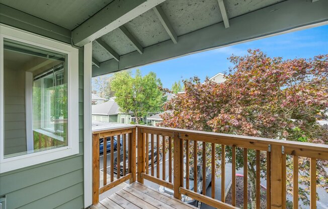 A wooden balcony with a trees in the distance