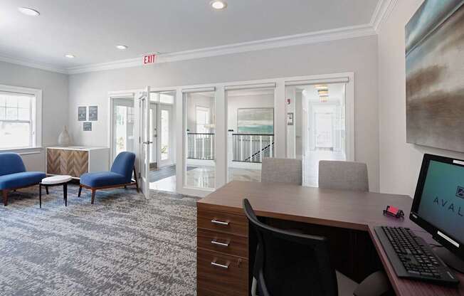 a conference room with a desk and chairs and a computer