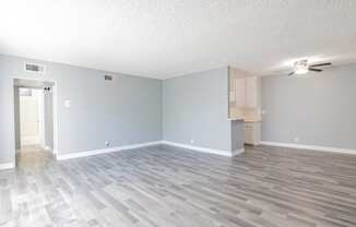 an empty living room with blue walls and a wood floor