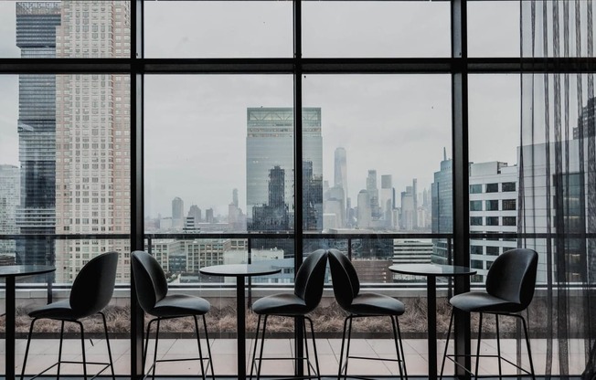 a view of the city skyline from a restaurant with tables and chairs at The Lively, Jersey City, NJ 07302