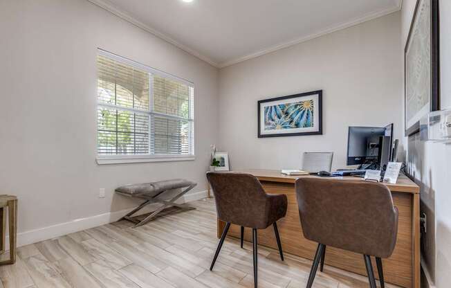 A room with a desk and two chairs.
