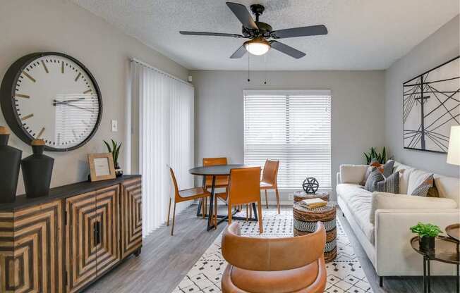 Open living area with round table, ceiling fan, and cozy seating.