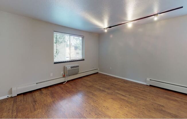 Bright living space with track lighting and hardwood floors