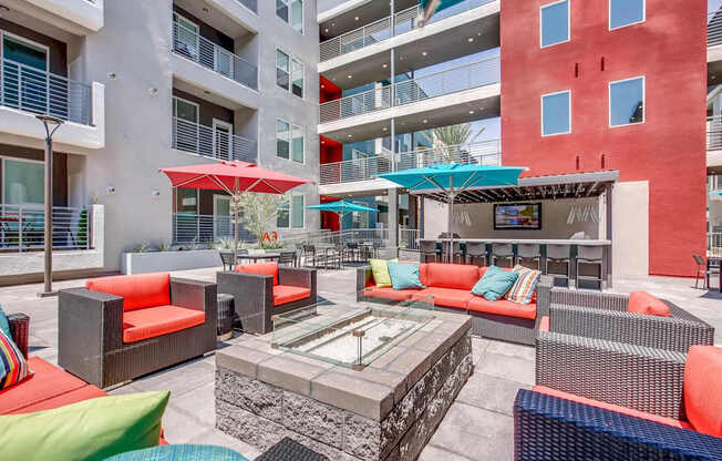 A patio with a table and chairs is surrounded by apartment buildings.